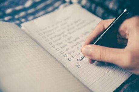 Year-End Financial Planning Checklist with hand and pen.