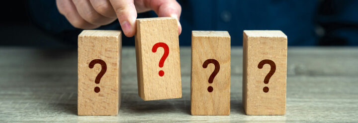 Fact finding is depicted by a man's hand selecting one of four wood blocks that have a question mark printed on them.