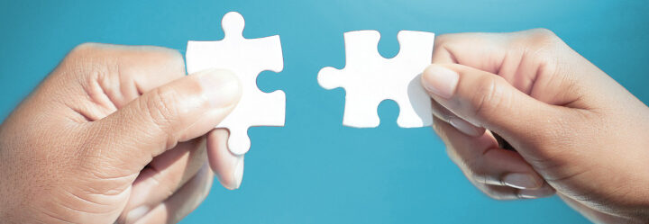 Fit call image of two hands holding two puzzle pieces that fit together.