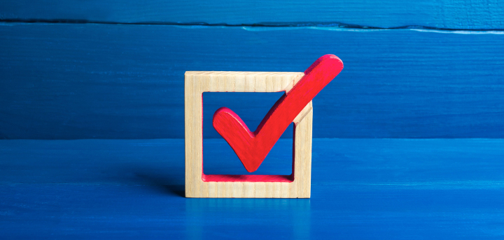 Implementation concept photo depicts a wood square checkbox with a red wood check marking it.