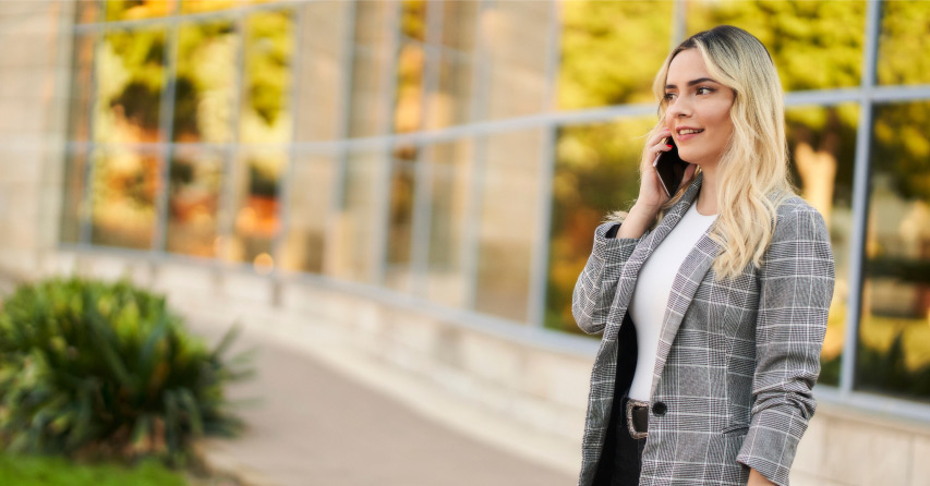 Women investors concept with woman using a cell phone outside an office building.