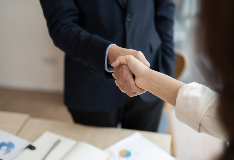 Buy-sell agreements concept with man and woman shaking hands.