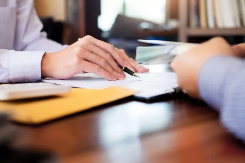 Risk management concept with female advisor going over documents with a male client.